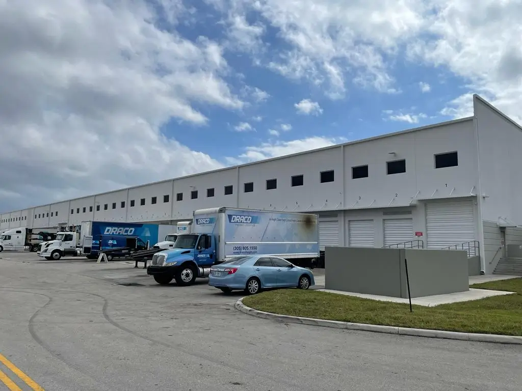 Exterior view of Draco Freight Logistics’ warehouse facility in Miami, featuring company trucks ready for local and regional freight distribution.