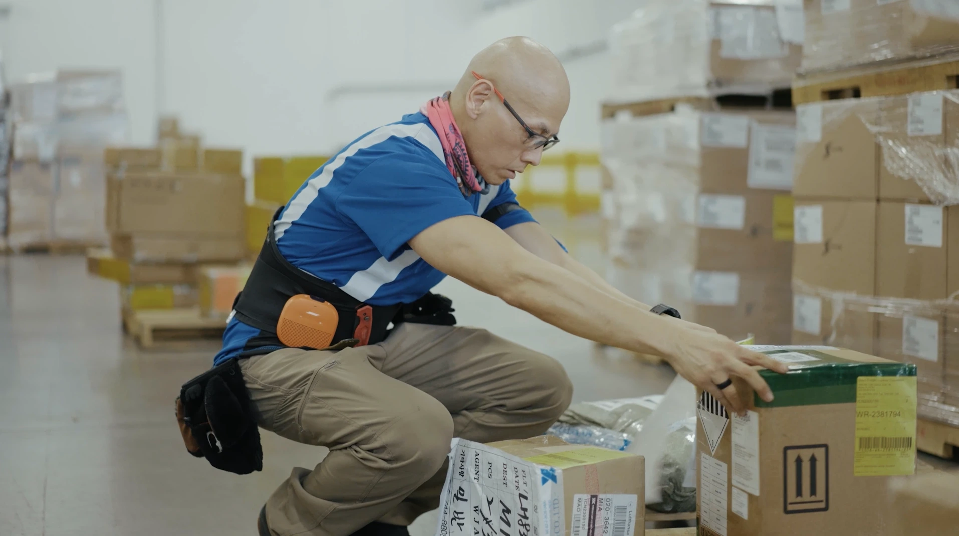 Logistics worker preparing and securing packaged cargo inside a warehouse