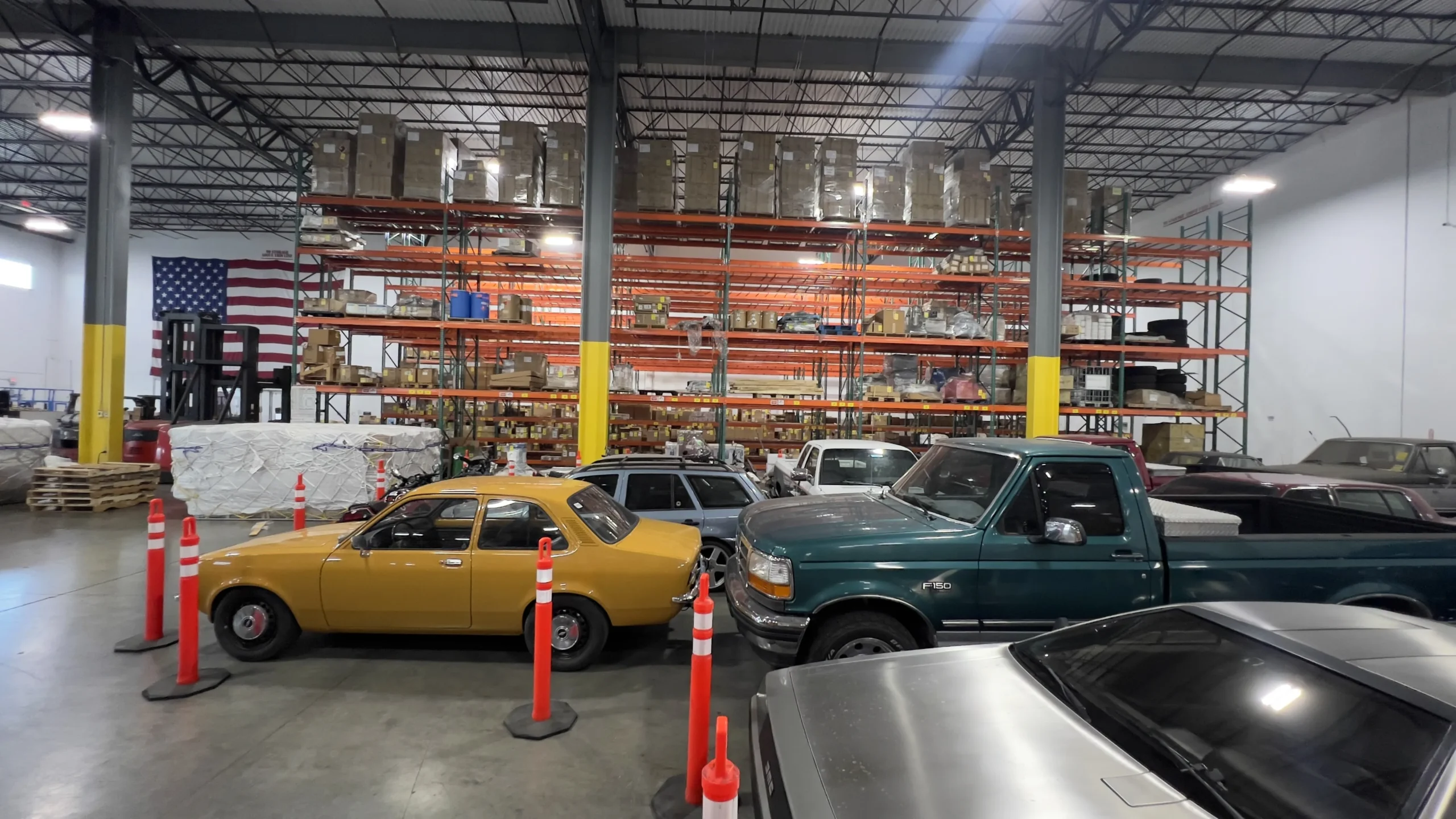 Multiple classic and modern vehicles arranged inside the Draco Freight Logistics warehouse, highlighting secure automotive logistics and roll-on/roll-off handling capabilities.