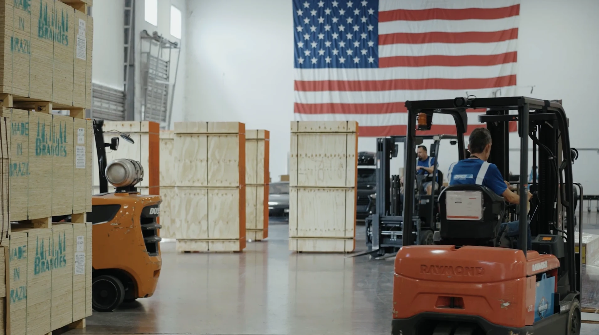Forklift operators transport large wooden crates inside the Draco Freight Logistics warehouse, demonstrating careful handling and secure movement of high-value and sensitive cargo.