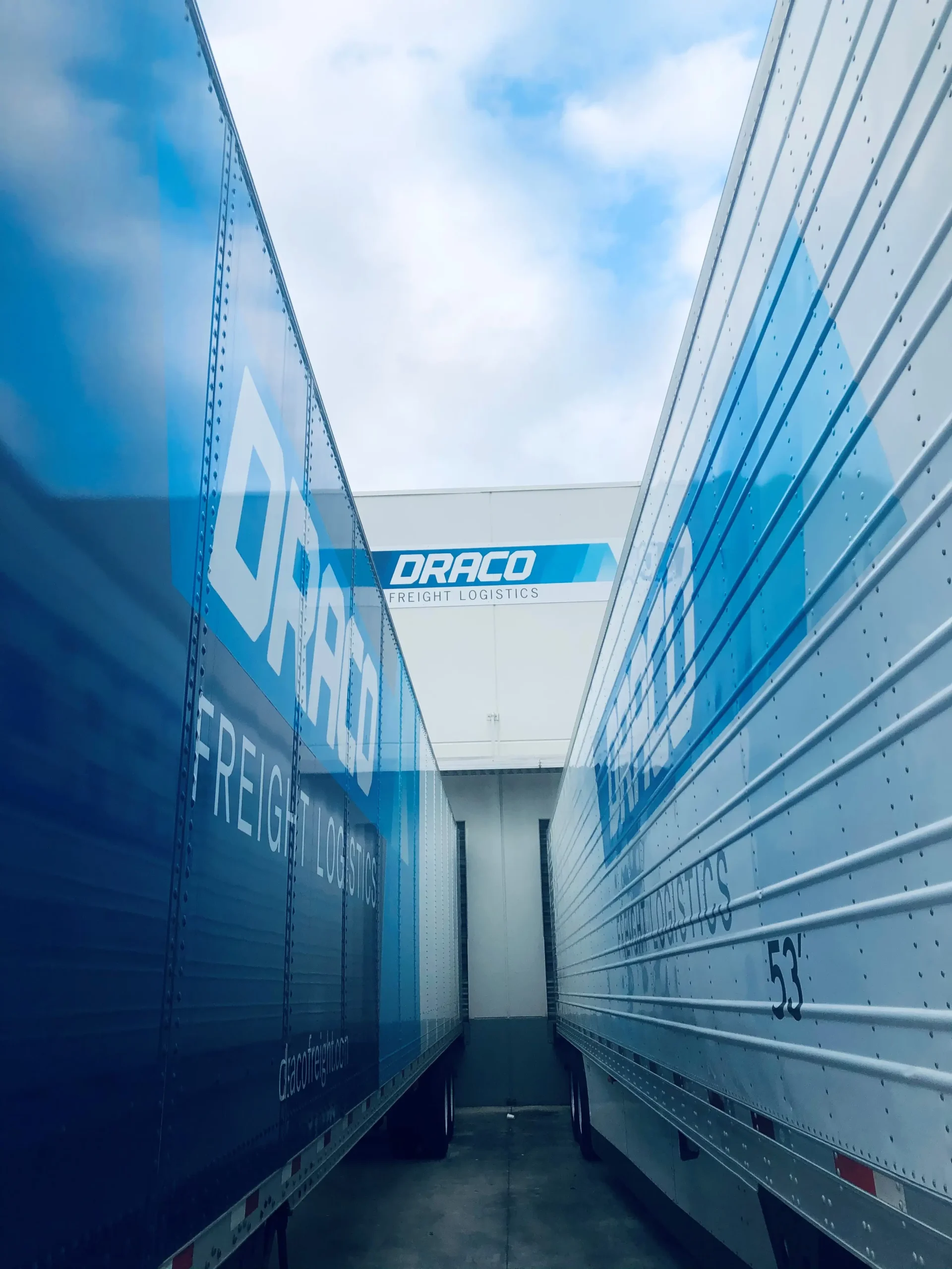 Draco Freight Logistics temperature-controlled reefer trailers positioned at the warehouse loading dock, ready for cold-chain and perishable freight operations